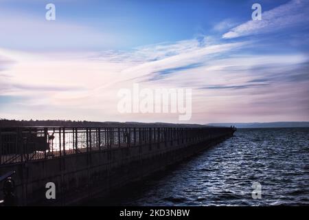 Zwei versilbte Fischer fischen vor dem Skaneateles Pier über dem Skaneateles Lake in der Finger Lakes Region im Bundesstaat New York Stockfoto