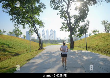 Eine Frau mit Gesichtsmaske als vorbeugende Maßnahme gegen die Ausbreitung von COVID-19 joggt am 27. Februar 2022 im Benchakitti Forest Park in Bangkok, Thailand. Wie Thailand COVID-19 Situation heute, berichtete die 24.719 neuen Fälle, 42 Todesfälle. (Foto von Vachira Vachira/NurPhoto) Stockfoto