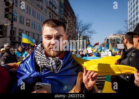 Ein Protestler trägt eine riesige ukrainische Flagge, während sich eine pro-ukrainische Kundgebung vom McPherson-Platz ins Weiße Haus bewegt. Tausende von Menschen aus den Vereinigten Staaten versammelten sich, um den USA und anderen Ländern für ihre Hilfe zu danken und eine Flugverbotszone und andere Hilfe für die Ukraine zu fordern. Die Veranstaltung wurde von United Help Ukraine und US-ukrainischen Aktivisten gesponsert, sowohl von US-amerikanischer Hilfsorganisation als auch von Interessenvertretung (Foto: Allison Bailey/NurPhoto) Stockfoto