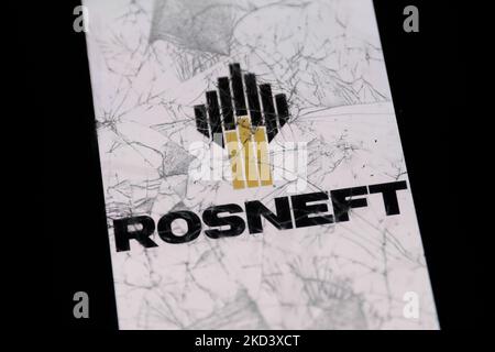 Das Rosneft-Logo, das auf einem Telefonbildschirm angezeigt wird, ist durch ein zerbrochenes Glas zu sehen. Dieses Bild wurde am 28. Februar 2022 in Krakau, Polen, aufgenommen. (Foto-Illustration von Jakub Porzycki/NurPhoto) Stockfoto