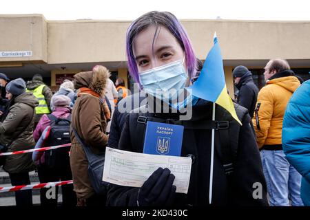 Eine junge ukrainische Frau mit ihrem Pass, ihrer Nationalflagge und einer Schlange für Zugtickets, um von Przemysl, Polen, aus in einen Zug nach Lemberg zu steigen, wie viele Ukrainer, einschließlich Frauen, beschlossen, in ihr Land zurückzukehren, um ihre Familie vor der russischen Invasion zu bekämpfen und zu unterstützen - 2. März 2022. Sie sagt, sie geht, um für ihr Land zu kämpfen. Da die Armee der Russischen Föderation die ukrainischen Grenzen überschritten hat, wird der Konflikt zwischen der Ukraine und Russland voraussichtlich bis zu 4 Millionen Ukrainer zur Flucht zwingen. Die russische Armee wurde von der ukrainischen Armee und den Zivilpersonen mit heftiger Opposition konfrontiert. (Foto von Dominika Zarzycka/NurPhoto) Stockfoto