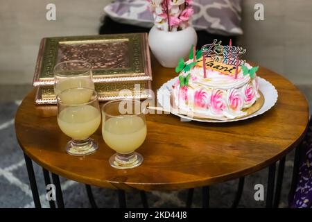 Geburtstagskuchen für die Großmutter mütterlicherseits, dekoriert mit Kerzen und Saftgläsern am Couchtisch Stockfoto