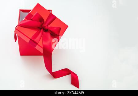 Rote Geschenkbox mit rotem Passionsband isoliert Ausschnitt auf weißem Hintergrund. Valentinstag Jubiläum Weihnachten Geburtstagsgeschenk. Speicherplatz kopieren Stockfoto