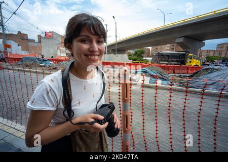 Medellin, Antioquia, Kolumbien - Juni 2 2022: Junge braune Frau geht mit einer Kamera mit Strap um den Hals an Einem sonnigen Tag Weitwinkel Stockfoto