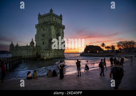 Am Ufer des Flusses Tejo in Lissabon werden Menschen bei Sonnenuntergang gesehen. 28. Februar 2022. Besucher versammeln sich um den Belem-Turm, um den Sonnenuntergang vor dem Ende des Winters zu erleben. (Foto von Jorge Mantilla/NurPhoto) Stockfoto