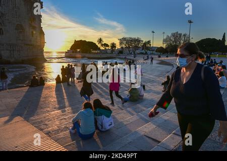 Am Ufer des Flusses Tejo in Lissabon werden Menschen bei Sonnenuntergang gesehen. 28. Februar 2022. Besucher versammeln sich um den Belem-Turm, um den Sonnenuntergang vor dem Ende des Winters zu erleben. (Foto von Jorge Mantilla/NurPhoto) Stockfoto