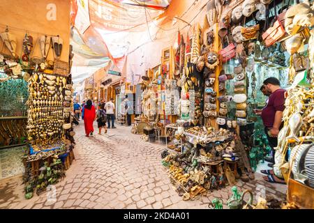 MARRAKESCH, MAROKKO - 2. NOV 22: Traditionelle Geschäfte in der Medina von Marrakesch tagsüber. Menschen sind in und außerhalb der Geschäfte zu sehen Stockfoto