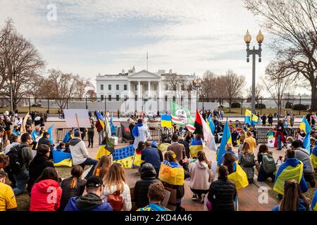 Demonstranten knien in einem Moment des Schweigens für diejenigen, die während einer Kundgebung im Weißen Haus in der Ukraine getötet wurden. Hunderte von Menschen versammelten sich, um eine Flugverbotszone der NATO und militärische Unterstützung für die Ukraine zu fordern. Dies ist der 10.-tägige Tag der Demonstrationen im Weißen Haus für die Ukraine in Folge. (Foto von Allison Bailey/NurPhoto) Stockfoto