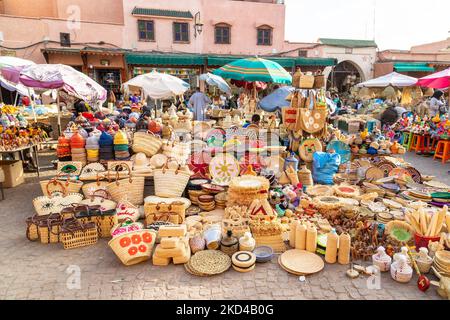 MARRAKESCH, MAROKKO - 3.. NOV 22: Ein Marktstand in der Medina von Marrakesch, der Korbkörbe, Taschen, Schalen und andere Gegenstände verkauft. Menschen können gesehen werden nea Stockfoto