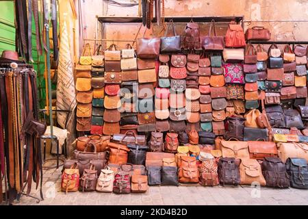 Ledertaschen und andere Artikel zum Verkauf vor einem Geschäft in der Medina / Souks von Marrakesch Stockfoto