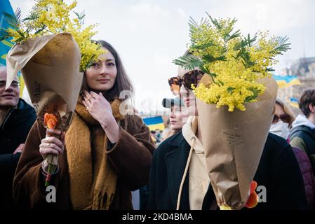 Zwei junge Frauen stehen mitten in der Menge mit gelben Blumen in den Armen während der Demonstration, die mehrere tausend Menschen zusammenbrachte, die sich in Paris versammelten, um an einem großen marsch vom Place de la République zum Place de la Bastille teilzunehmen, um Frieden in der Ukraine zu fordern Am 10.. Tag der Invasion Russlands. Viele politische Persönlichkeiten und Bürger marschierten am 5. März 2022 in Paris unter ukrainischen Flaggen und Slogans für den Frieden und gegen Putin. (Foto von Samuel Boivin/NurPhoto) Stockfoto