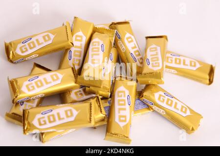 Stapel von McVities Gold-Riegel in grobem Stapel - mehrere goldene Schokoladen-Riegel als Snack-Leckerbissen Stockfoto