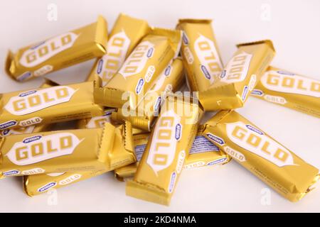 Stapel von McVities Gold-Riegel in grobem Stapel - mehrere goldene Schokoladen-Riegel als Snack-Leckerbissen Stockfoto