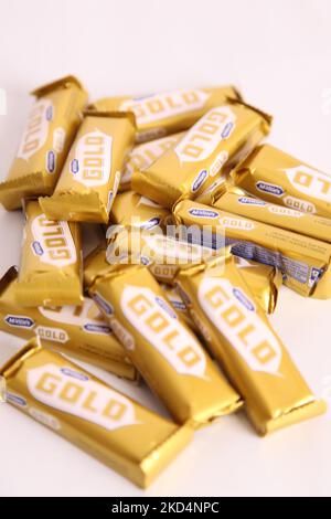 Stapel von McVities Gold-Riegel in grobem Stapel - mehrere goldene Schokoladen-Riegel als Snack-Leckerbissen Stockfoto