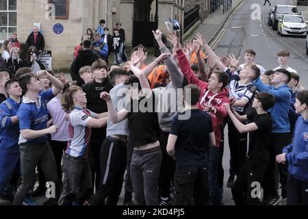 Jedburgh, Donnerstag, 10. März 2022. Eine Gruppe von Jugendlichen Herausforderung für die â € œBaâ € â € œhailedâ € während der jährlichen "Fastern Eve Handba" Veranstaltung in Jedburgh High Street in den Scottish Borders am 10. März 2022 in Jedburgh, Schottland. Die jährliche Veranstaltung, die im 18. Jahrhundert begann, findet heute statt und umfasst zwei Teams, die Uppies (Bewohner aus dem oberen Teil von Jedburgh) und die Doonies (Bewohner aus dem unteren Teil von Jedburgh), die den Ball entweder auf den oberen oder unteren Rand der Stadt bringen. Der Ball, der aus Leder besteht, mit Stroh gefüllt und mit Bändern verziert ist, wird in die Menge geworfen Stockfoto