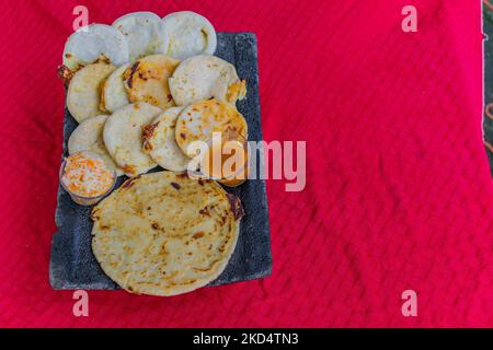Typisch salvadorianisches Gericht, Käse-Pupusas mit Kohl und Tomatensauce. Reis- und Maispupusas gefüllt mit Käse, Bohnen oder anderen Zutaten Stockfoto