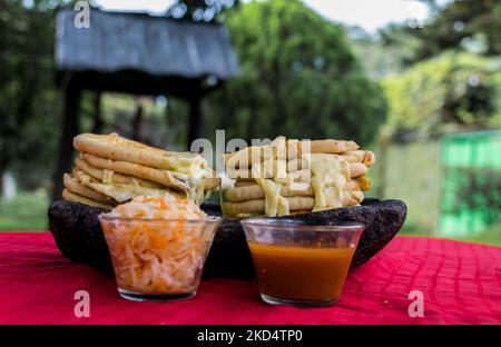 Typisch salvadorianisches Gericht, Käse-Pupusas mit Kohl und Tomatensauce. Reis- und Maispupusas gefüllt mit Käse, Bohnen oder anderen Zutaten Stockfoto