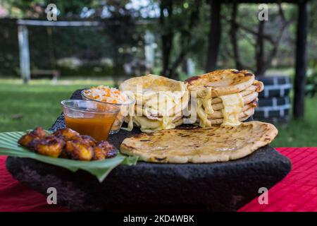 Typisch salvadorianisches Gericht, Käse-Pupusas mit Kohl und Tomatensauce. Reis- und Maispupusas gefüllt mit Käse, Bohnen oder anderen Zutaten Stockfoto