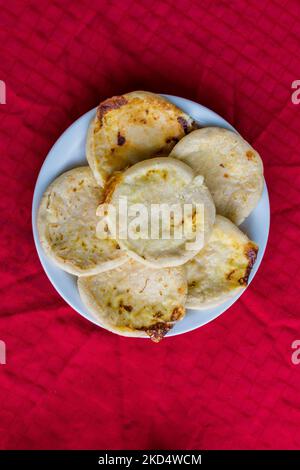 Typisch salvadorianisches Gericht, Käse-Pupusas mit Kohl und Tomatensauce. Reis- und Maispupusas gefüllt mit Käse, Bohnen oder anderen Zutaten Stockfoto