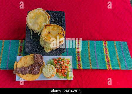 Typisch salvadorianisches Gericht, Käse-Pupusas mit Kohl und Tomatensauce. Reis- und Maispupusas gefüllt mit Käse, Bohnen oder anderen Zutaten Stockfoto