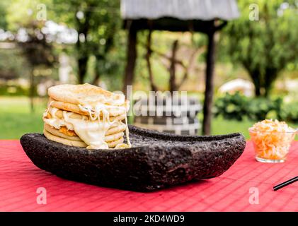 Typisch salvadorianisches Gericht, Käse-Pupusas mit Kohl und Tomatensauce. Reis- und Maispupusas gefüllt mit Käse, Bohnen oder anderen Zutaten Stockfoto