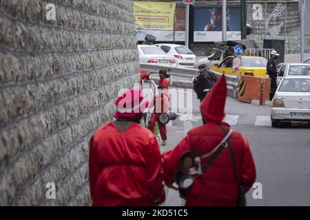 Ein junger Iraner malte sein Gesicht in Schwarz und trug rote Kleider, als Hajji Firuz (ein iranisches Neujahrssymbol) am 12. März 2022 auf einer Straße im Norden Teherans Musik spielt. Hajji Firuz ist eine fiktive Figur in der iranischen Folklore, die zu Beginn von Nowruz auf den Straßen auftaucht. Sein Gesicht ist mit Ruß bedeckt, und er ist in leuchtend rote Kleider gekleidet. Er tanzt durch die Straßen, singt und spielt Musik. (Foto von Morteza Nikoubazl/NurPhoto) Stockfoto