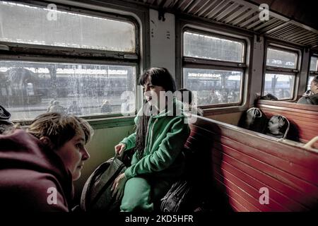 Junge Frauen, die aufgrund des Krieges aus dem Land fliehen mussten, warteten auf die Abfahrt des Zuges. Ukrainische Menschen, Kriegsflüchtlinge, wie sie in einem alten Eisenbahnwagen zu sehen sind, kommen schnell ein, nachdem sie unterirdisch am Bahnhof Lwiw gewartet haben, und fahren durch den Zug, um in die Wagen zu kommen, weil der Bahnhof als militärisches Ziel angesehen wird. Der Zug wird die polnisch-ukrainischen Grenzen überqueren und weiter nach Polen und anderen europäischen Ländern reisen. Am 15. März ertönten die Sirenen für den Luftangriff zweimal, eine morgens und eine abends. Nach Angaben der UN - UNHCR verließen mehr als 3,3 Millionen Flüchtlinge die Stockfoto