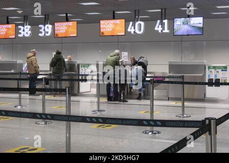 Mitarbeiter am Check-in-Schalter der Billigfluggesellschaft easyJet liefern ihr Gepäck ab. Kraków John Paul II International Airport KRK bekannt als Krakow Balice Airport. Check-in-Schalter, Ankunfts- und Abflughalle sowie der Gates-Bereich des polnischen Flughafenterminals. Es ist der zweitgrößte Flughafen in Bezug auf den Passagierverkehr in Polen. Die Luftfahrtindustrie und das Passagieraufkommen befinden sich in einer schwierigen Phase, da die Coronavirus-Pandemie Covid-19 negative Auswirkungen auf die Reisebranche hat und aufgrund der neuen Variantenmutation wie Omicron am Fft eine Verschlechterung der Situation befürchtet wird Stockfoto