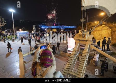 Eine iranische Frau fotografiert mit ihrem Smartphone im Wasser- und Feuerpark im Norden Teherans als Feuerwerk über der Naturbrücke, um am 20. März 2022 den Beginn des iranischen Neujahrs zu feiern. (Foto von Morteza Nikoubazl/NurPhoto) Stockfoto