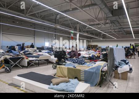 Temporärer Schlafbereich mit Campingbetten und Matratzen für Menschen im ehemaligen Einkaufszentrum. Das temporäre Zentrum für humanitäre Hilfe in Przemysl, einer Stadt 10km aus der Ukraine und dem Grenzübergang Medyka Shehyni. Das humanitäre Zentrum war ein ehemaliges Einkaufszentrum, das von Freiwilligen, Wohltätigkeitsorganisationen, NGOs, den lokalen Behörden und den polnischen Streitkräften in das größte Hilfszentrum der Region umgewandelt wurde. Ukrainische Flüchtlinge können Unterkunft, Schlaf, medizinische Hilfe, Nahrung finden, sich registrieren und ihren Transport für die Umsiedlung nach Europa oder Polen organisieren. Nach Angaben der UN - UNHCR mehr als 3,3 m Stockfoto