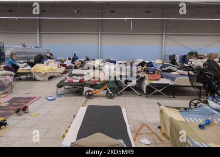 Temporärer Schlafbereich mit Campingbetten und Matratzen für Menschen im ehemaligen Einkaufszentrum. Das temporäre Zentrum für humanitäre Hilfe in Przemysl, einer Stadt 10km aus der Ukraine und dem Grenzübergang Medyka Shehyni. Das humanitäre Zentrum war ein ehemaliges Einkaufszentrum, das von Freiwilligen, Wohltätigkeitsorganisationen, NGOs, den lokalen Behörden und den polnischen Streitkräften in das größte Hilfszentrum der Region umgewandelt wurde. Ukrainische Flüchtlinge können Unterkunft, Schlaf, medizinische Hilfe, Nahrung finden, sich registrieren und ihren Transport für die Umsiedlung nach Europa oder Polen organisieren. Nach Angaben der UN - UNHCR mehr als 3,3 m Stockfoto