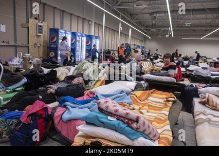 Temporärer Schlafbereich mit Campingbetten und Matratzen für Menschen im ehemaligen Einkaufszentrum. Das temporäre Zentrum für humanitäre Hilfe in Przemysl, einer Stadt 10km aus der Ukraine und dem Grenzübergang Medyka Shehyni. Das humanitäre Zentrum war ein ehemaliges Einkaufszentrum, das von Freiwilligen, Wohltätigkeitsorganisationen, NGOs, den lokalen Behörden und den polnischen Streitkräften in das größte Hilfszentrum der Region umgewandelt wurde. Ukrainische Flüchtlinge können Unterkunft, Schlaf, medizinische Hilfe, Nahrung finden, sich registrieren und ihren Transport für die Umsiedlung nach Europa oder Polen organisieren. Nach Angaben der UN - UNHCR mehr als 3,3 m Stockfoto