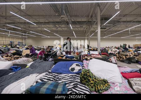 Temporärer Schlafbereich mit Campingbetten und Matratzen für Menschen im ehemaligen Einkaufszentrum. Das temporäre Zentrum für humanitäre Hilfe in Przemysl, einer Stadt 10km aus der Ukraine und dem Grenzübergang Medyka Shehyni. Das humanitäre Zentrum war ein ehemaliges Einkaufszentrum, das von Freiwilligen, Wohltätigkeitsorganisationen, NGOs, den lokalen Behörden und den polnischen Streitkräften in das größte Hilfszentrum der Region umgewandelt wurde. Ukrainische Flüchtlinge können Unterkunft, Schlaf, medizinische Hilfe, Nahrung finden, sich registrieren und ihren Transport für die Umsiedlung nach Europa oder Polen organisieren. Nach Angaben der UN - UNHCR mehr als 3,3 m Stockfoto