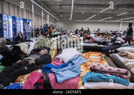 Temporärer Schlafbereich mit Campingbetten und Matratzen für Menschen im ehemaligen Einkaufszentrum. Das temporäre Zentrum für humanitäre Hilfe in Przemysl, einer Stadt 10km aus der Ukraine und dem Grenzübergang Medyka Shehyni. Das humanitäre Zentrum war ein ehemaliges Einkaufszentrum, das von Freiwilligen, Wohltätigkeitsorganisationen, NGOs, den lokalen Behörden und den polnischen Streitkräften in das größte Hilfszentrum der Region umgewandelt wurde. Ukrainische Flüchtlinge können Unterkunft, Schlaf, medizinische Hilfe, Nahrung finden, sich registrieren und ihren Transport für die Umsiedlung nach Europa oder Polen organisieren. Nach Angaben der UN - UNHCR mehr als 3,3 m Stockfoto