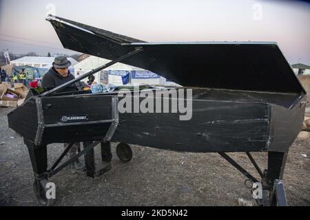 Davide Martello, der deutsche Pianist italienischer Abstammung, bekannt als Klavierkunst, spielt in Medyka, am ukrainischen polnischen Grenzübergang von Medyka Shehyni. Der Musiker, ein Künstler, spielt in der Nähe der ukrainischen Grenze für die ankommenden Kriegsflüchtlinge aus der Ukraine vor den Zelten und Bussen, die sie zur Umsiedlung bringen. Tausende von zivilen Flüchtlingen überqueren aufgrund der russischen Invasion in die Ukraine täglich die ukrainisch-polnische Grenze. Medyka, Polen am 14. März 2022 (Foto von Nicolas Economou/NurPhoto) Stockfoto