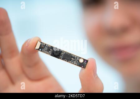 Mädchen hält in ihren Händen eine Miniatur-Videokamera für verdeckte Videoüberwachungssysteme Stockfoto