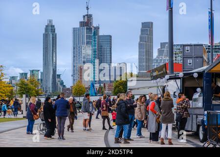 Leute, die Schlange stehen, um Erfrischungen vom Straßennahrungswagen vor dem Battersea Power Station zu kaufen. Hochhäuser im Hintergrund. Wandsworth, London. Stockfoto