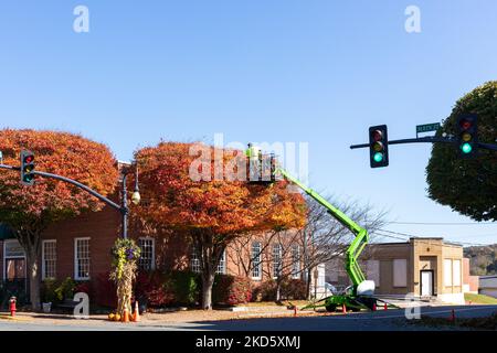 GALAX, VIRGINIA, USA-15. OKTOBER 2022: Arbeiter trimmen Baum aus hydraulischen Aufzug. Farbenfroher Herbsttag. Stockfoto