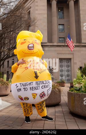 Ein Protestler in einem aufblasbaren Donald Trump Babykostüm feuert die Teilnehmer eines Streiks gegen den Klimawandel durch die jugendgeführte Organisation Fridays for Future an, als sie das Justizministerium passieren. Sie und eine andere Person protestierten gegen die Untätigkeit des US-Außenministeriums, Donald Trump zur Rechenschaft zu ziehen und die Stimmrechte zu schützen. Diese Veranstaltung war eine von vielen, die im März 25 von FFF, der globalen Organisation, die 2018 von Greta Thunberg gegründet wurde, weltweit abgehalten wurde. Die Demonstranten fordern von den politischen Entscheidungsträgern und dem privaten Sektor Maßnahmen gegen die Klimakrise und Reparationen für die einfache Bevölkerung - in erster Linie Stockfoto