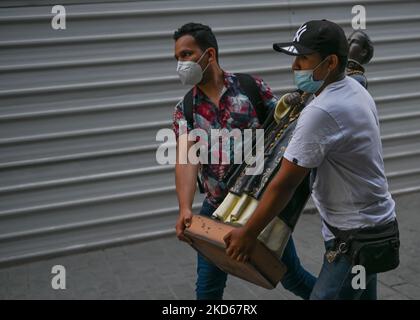 Zwei junge Männer mit Gesichtsmasken tragen eine religiöse Statue im Zentrum von Lima. Am Sonntag, 27. März 2022, in Lima, Peru. (Foto von Artur Widak/NurPhoto) Stockfoto