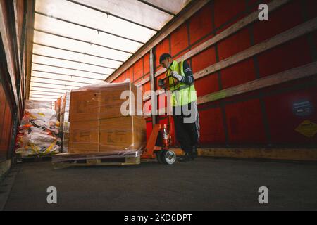 Ein Mitarbeiter der HGK (RheinCargo GmbH) lädt am 31. März 2022 im Hafen von Niehl auf dem Parkplatz der RheinCargo GmbH in Köln gespendete Waren in einen großen Truckercontainer, bevor die Waren per Zug nach Kiew, Ukraine, transportiert werden. (Foto von Ying Tang/NurPhoto) Stockfoto