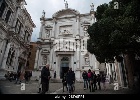 Passanten vor der Scuola Grande di San Rocco, dem Kunstmuseum, das Tintoretto gewidmet ist, und der Chiesa di San Rocco, im historischen Zentrum von Venedig, Italien, am 1. April 2022. (Foto von Andrea Savorani Neri/NurPhoto) Stockfoto