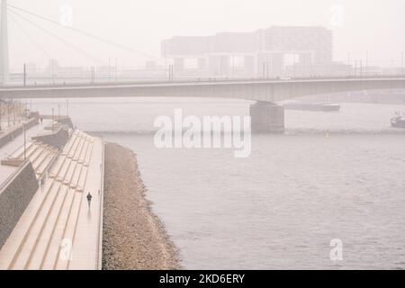 Ein Mann läuft am 1. April 2022 bei den Schneefällen in Köln am rhein entlang (Foto: Ying Tang/NurPhoto) Stockfoto