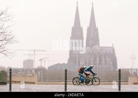 Bei den Schneefällen in Köln am 1. April 2022 werden Radfahrer am Rhein entlang fahren sehen (Foto: Ying Tang/NurPhoto) Stockfoto