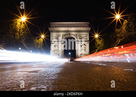 Die Lichtwege bei Nacht mit dem Arc de Triomphe im Hintergrund. Stockfoto