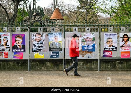 Ein Mann geht am 31. März 2022 in Clermont-Ferrand, Frankreich, in die Nähe der zerstörten Plakate der französischen Präsidentschaftskandidaten. (Foto von Adrien Fillon/NurPhoto) Stockfoto