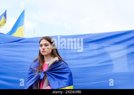 Ein ukrainischer Aktivist in Paris vor einer ukrainischen Flagge während einer Demonstration zur Unterstützung der Ukraine am 2. April 2022 in Paris, Frankreich. (Foto: Vincent Koebel/NurPhoto) Stockfoto