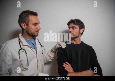 Der Arzt sieht dem Patienten in seiner Klinik direkt ins Auge. Stockfoto