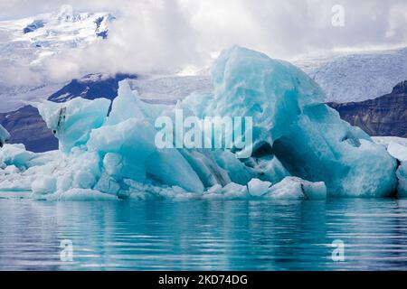 Ein großer Gletscher an der Glacier Lagoon in Island mit großen schneebedeckten Bergen im Hintergrund Stockfoto