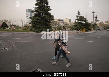 Zwei iranische Frauen, die Schutzmasken tragen, gehen am 8. April 2022 während einer verschmutzten Luft in Teheran entlang einer Allee. (Foto von Morteza Nikoubazl/NurPhoto) Stockfoto